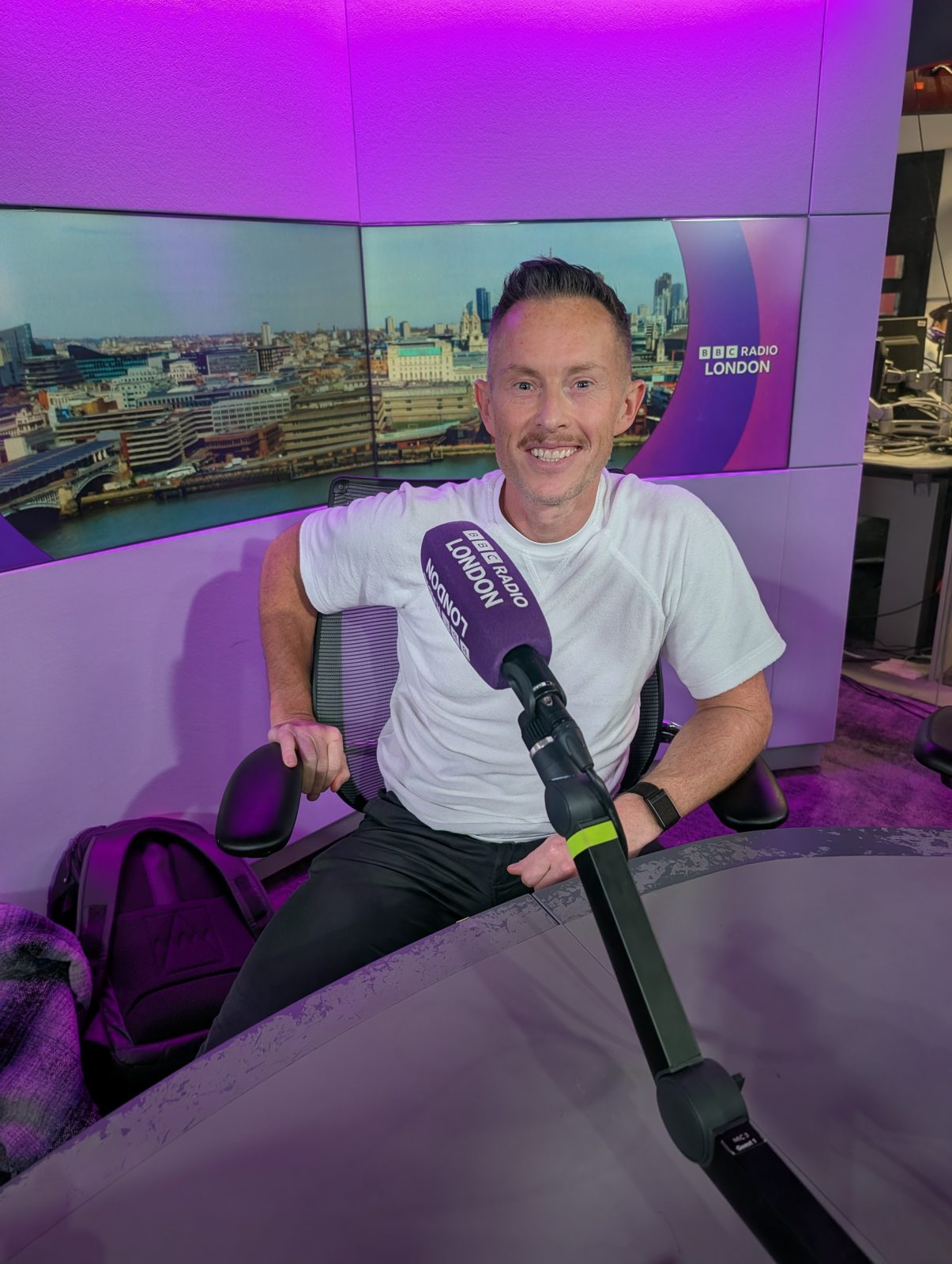 Russ Danks in a radio studio with a microphone