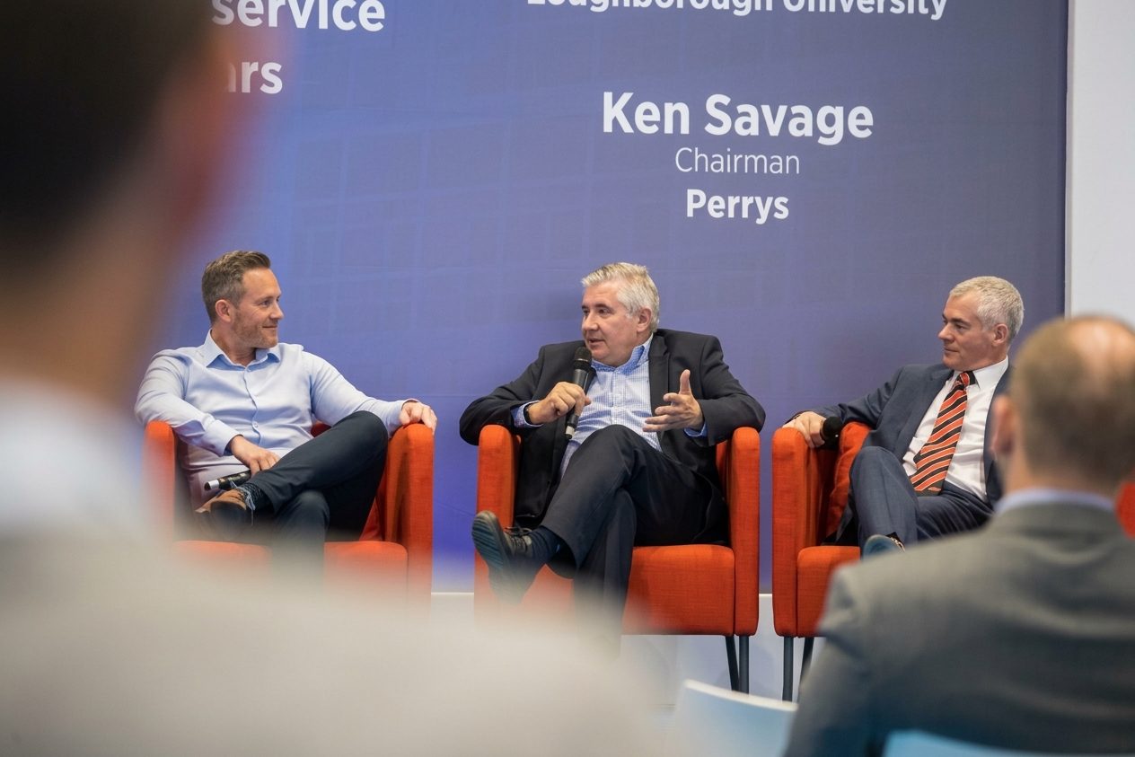 Three panellists in conversation on stage at an industry event